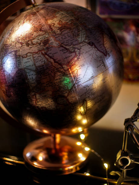 Close-up of a copper-colored globe on a piano