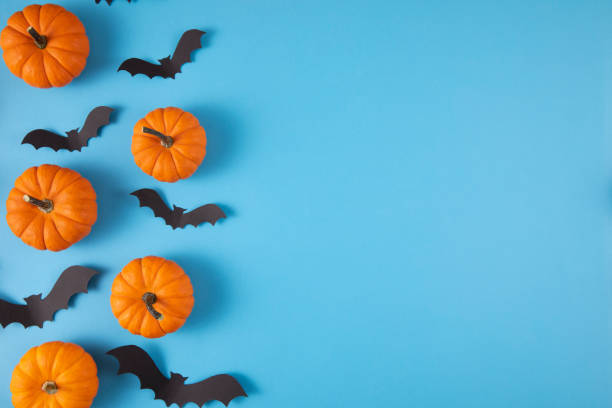 istock Halloween Decorations Pumpkins and Bats on Blue Background 1430960997