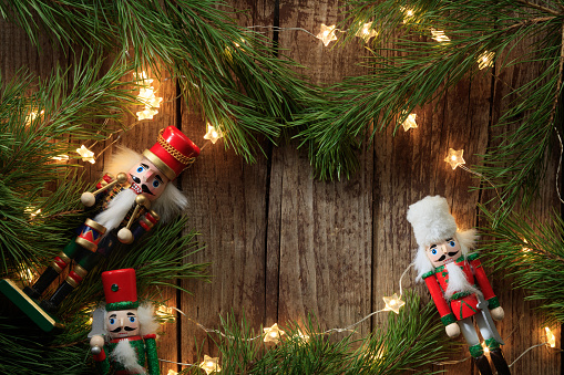 Christmas composition of coniferous branches, Nutcrackers toys and lighting garlands