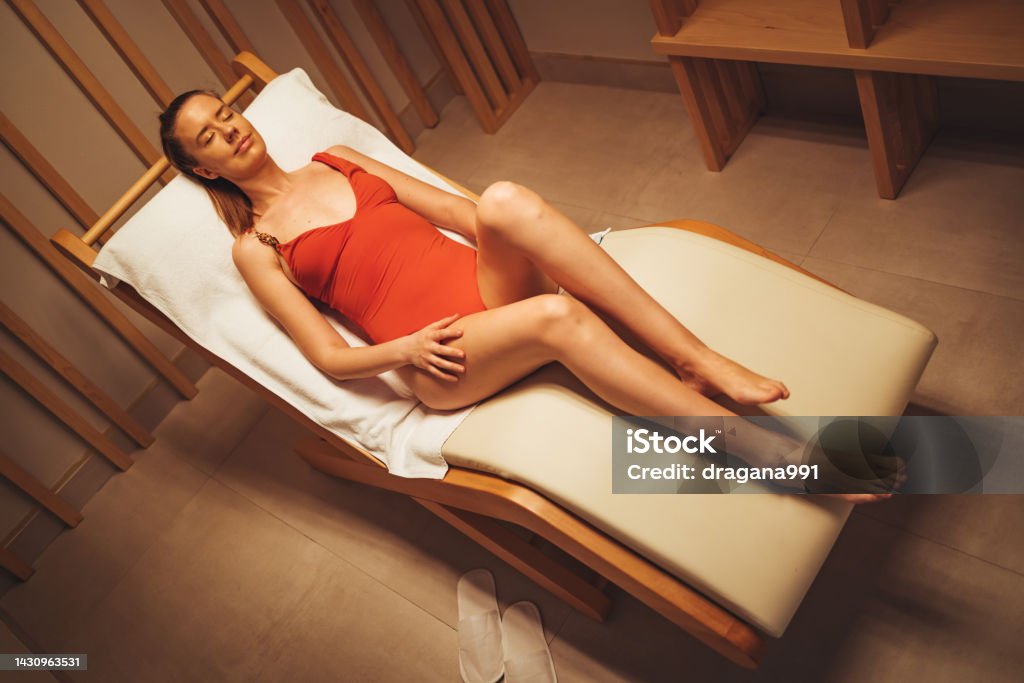 Spa treatment, alternative beauty therapy. Serene woman relaxing in infrared sauna. Spa treatment, alternative beauty therapy. The infrared sauna to improve the health and beauty.  Infrared panels for medical procedures, classic wooden sauna Infrared Stock Photo