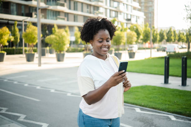 istock African American girl walking and using smartphone 1430964634