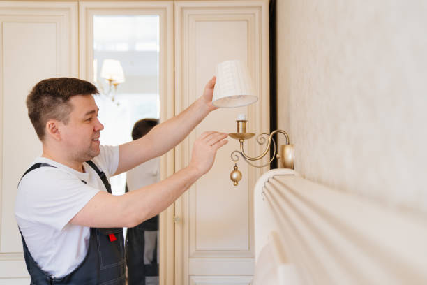 istock A male electrician changes the light bulbs and repairs in the sconces 1430965178