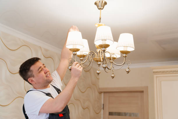 istock A male electrician changes the light bulbs in the ceiling light. 1430965349