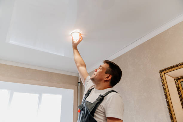 istock A male electrician changes the light bulbs in the spotlight ceiling lamp 1430965742