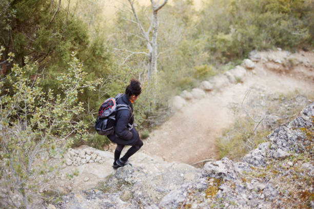 A woman walks on a hiking trail.