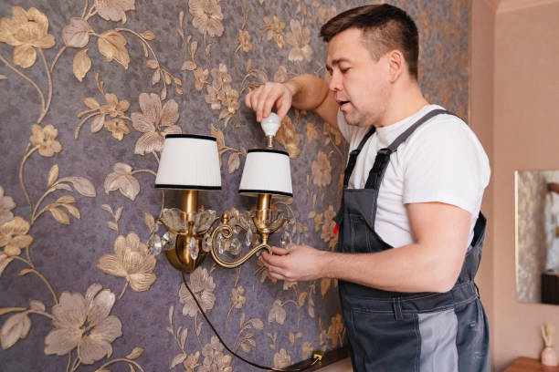 istock A male electrician changes the light bulbs and repairs in the sconces 1430967243