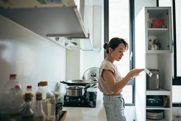 Photo of Asian women examining the shopping receipt at home