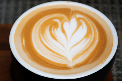 Hot coffee latte art serve on wooden tray for travelers thai people rest relax eat and drinks at cafe restaurant shop in Bangkok, Thailand