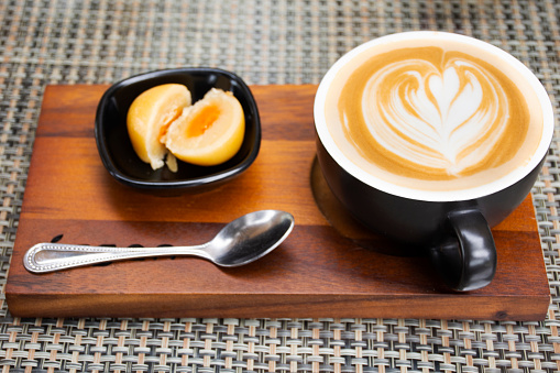 Hot coffee latte art serve with chinese pastry moon cake serve on wooden tray for travelers thai people rest relax eat and drinks at cafe restaurant shop in Bangkok, Thailand