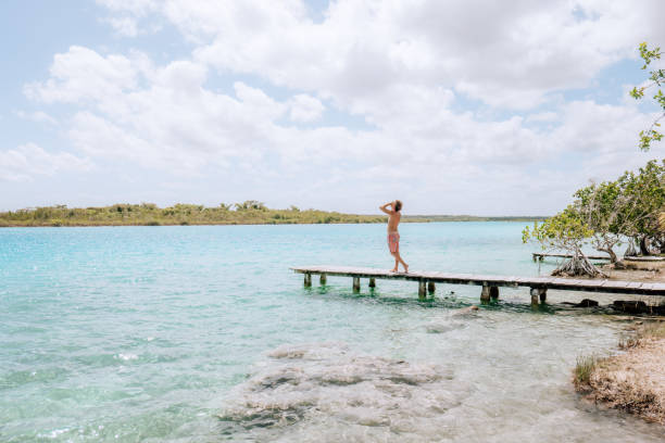 istock Young man on pier above blue lagoon contemplates the view 1430974695
