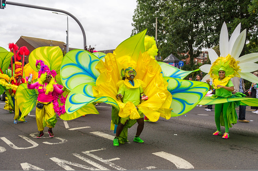 Leeds, United Kingdom - August 29, 2022: Women in giant flower costumes in the Leeds West Indian Carnival Parade on Aug 29, 2022 in Leeds, United Kingdom