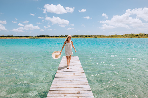 30's woman relaxes in nature on the beautiful lake of Bacalar, Mexico