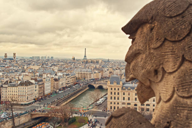 istock Notre Dame Paris aereal rooftop view stone gargoyle foreground and city view with eiffel tower cloudy sky vintage style 1430977225
