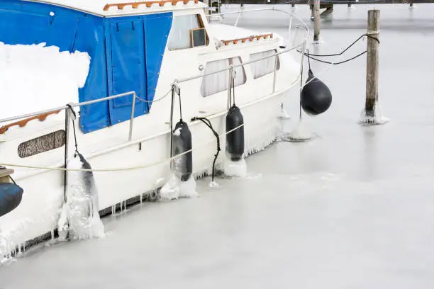 Photo of Erratic icicles on the fenders of a motorboat in wintertime.