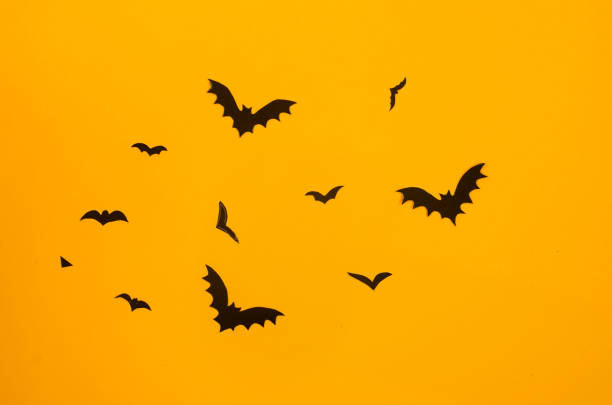 istock yellow background with black paper bats 1430979794
