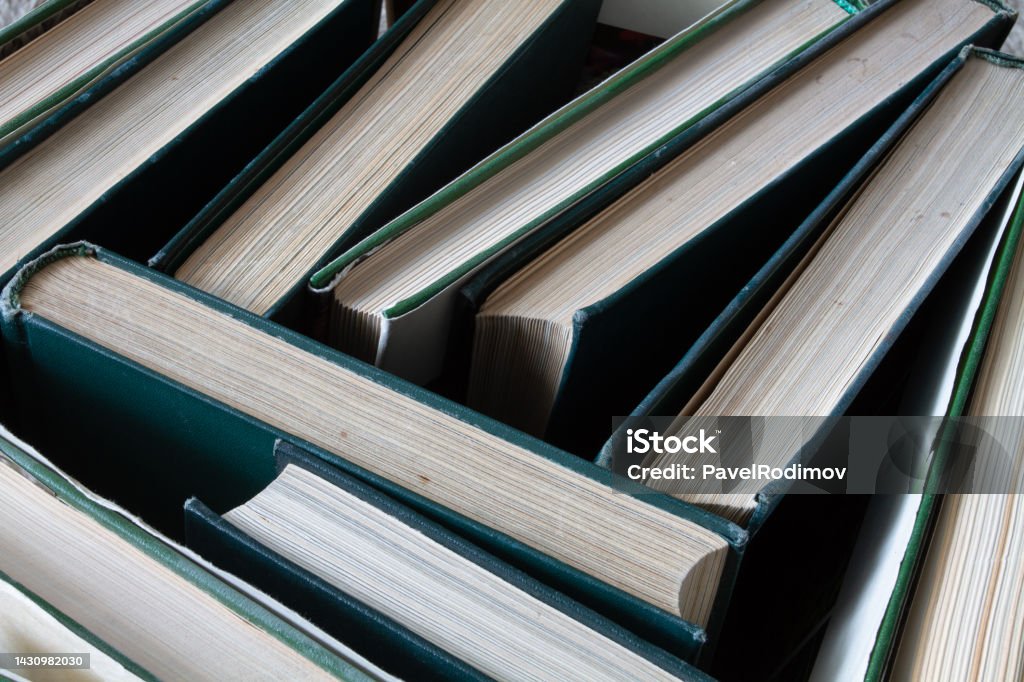 chaotic hodgepodge of books Many large books are arranged chaotically and closely. View from above. Book Stock Photo