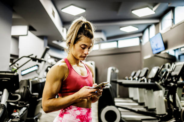 istock Professional fitness instructor using smartphone in the gym 1430986648