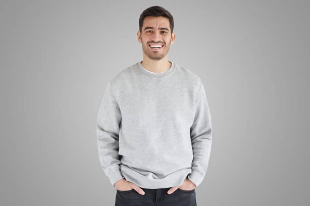 istock Daylight portrait of young laughing handsome man, wearing oversized sweatshirt on gray background 1430990164