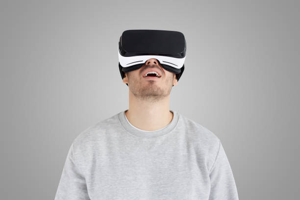 istock Amazed man experiencing virtual reality with VR headset on gray background 1430990283