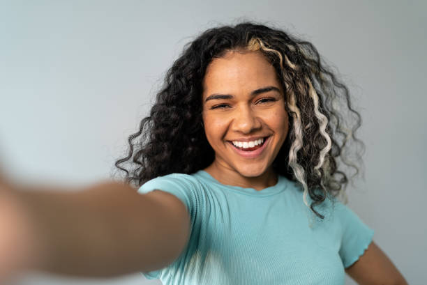 Young woman taking a selfie on a studio shot