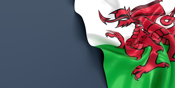 Partial Welsh flag is waving on blue gray background. Horizontal composition with copy space. Easy to crop for all your social media and print sizes.