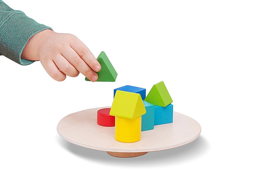 Child playing with colorful wooden toy bricks on white background