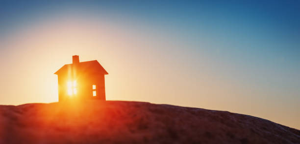 istock Model of a house standing on the ground on sunset evening. 1430996881