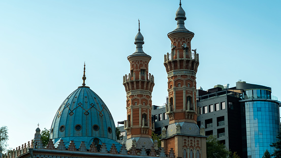 A mosque with two minarets in a residential area against the sky