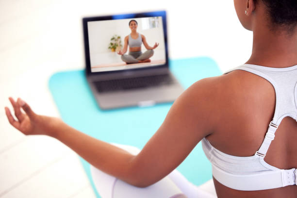 Streaming on laptop for yoga, meditation and zen tutorial, class and webinar in home lockdown or quarantine. Relaxed, healthy or calm woman meditating for balance, holistic breathing or mental health transmisión en computadora portátil para yoga, meditación y tutorial zen, clase y seminario web en confinamiento o cuarentena en casa. mujer relajada, sana o tranquila meditando para el equilibrio, la respiración holística o la salud mental