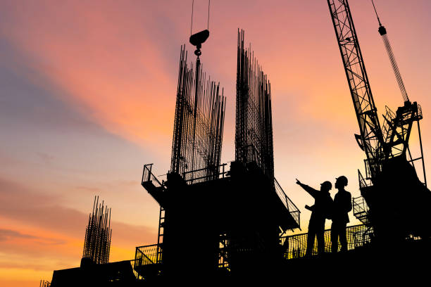istock Silhouette of Engineer and worker on building site, construction site at sunset in evening time 1431000349