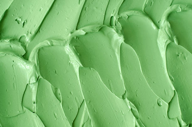 istock Green cosmetic clay (cucumber facial mask, avocado face cream, green tea matcha body wrap) texture close up, selective focus. Abstract background with brush strokes. 1431001234