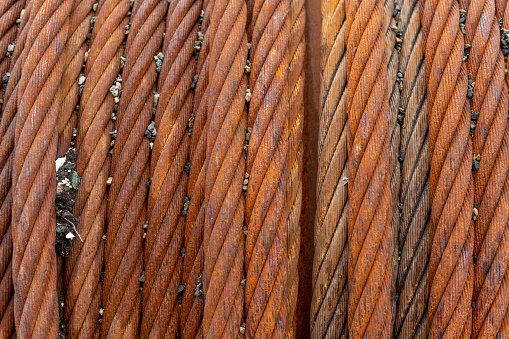 Close up of rusty steel cable coiled on a drum.