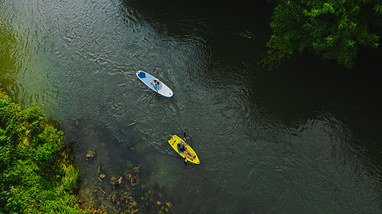 Photo of male friends with sup and kayak on the river