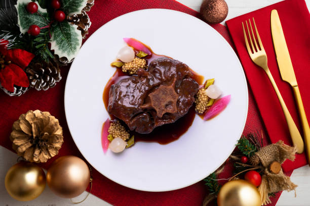 istock Tapa of oxtail cooked at low temperature with red wine sauce. Dish served on a table decorated with Christmas motifs. 1431010607