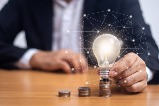 istock Businessman holding a light bulb on a coin (business growth concept) 1431011327