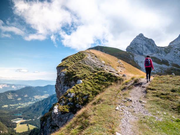 istock A girl with a backpack walking along a ridge in the sun. 1431013293