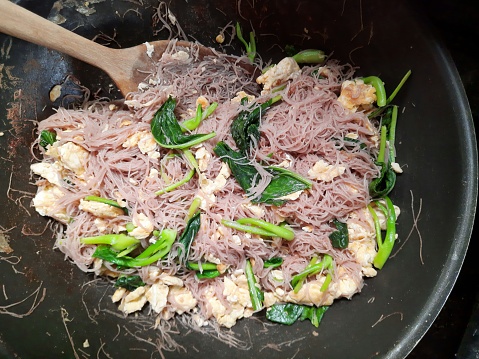 Cooking Stir fried Rice noodles and kale with egg - food preparation.