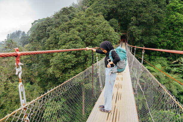 istock muslim woman carrying backpack walking on suspension bridge 1431019272