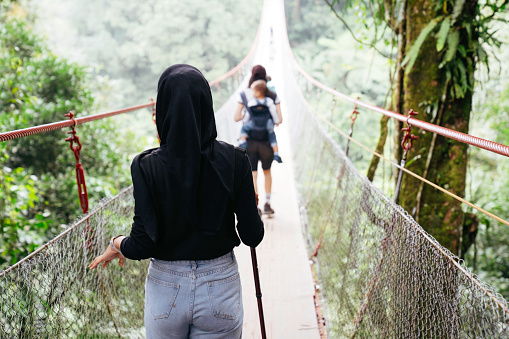 Chinese woman and muslim friend  woman walking together on the suspension bridge