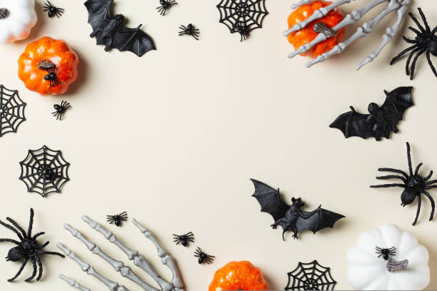Halloween greeting card with bats, spiderweb, spider, skull and pumpkins stock photo