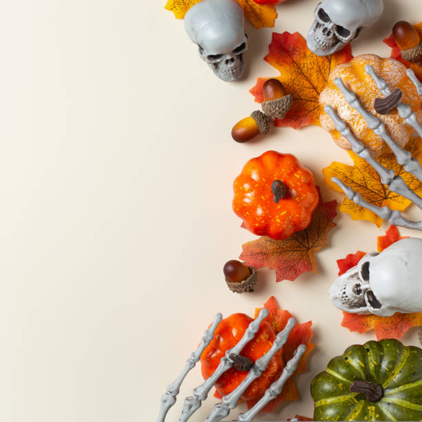 istock Halloween greeting card with pumpkin, skulls, bony hands and leaves 1431034167