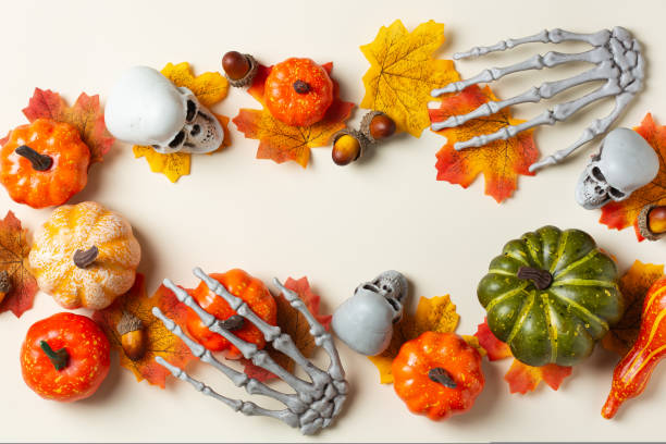 istock Halloween greeting card with pumpkin, skulls, bony hands and leaves 1431034343