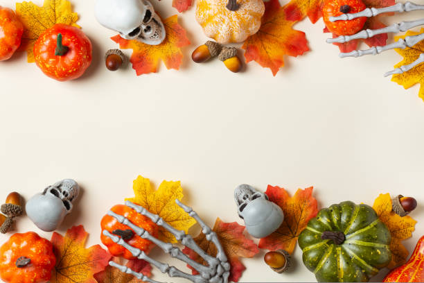 istock Halloween greeting card with pumpkin, skulls, bony hands and leaves 1431034712