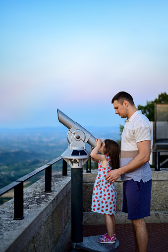 toddler girl with her dad looking in telescope in a mountain peak. telescope, using, curious, looking, seaside binoculars, summer vacation