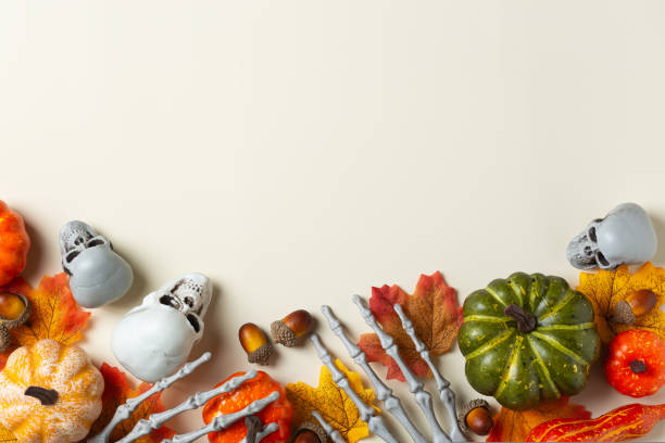 istock Halloween greeting card with pumpkin, skulls, bony hands and leaves 1431034916