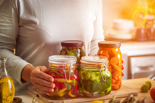 Mature hispanic woman preparing healthy vegetables pickles at home. High resolution 42Mp indoors digital capture taken with SONY A7rII and Zeiss Batis 40mm F2.0 CF lens