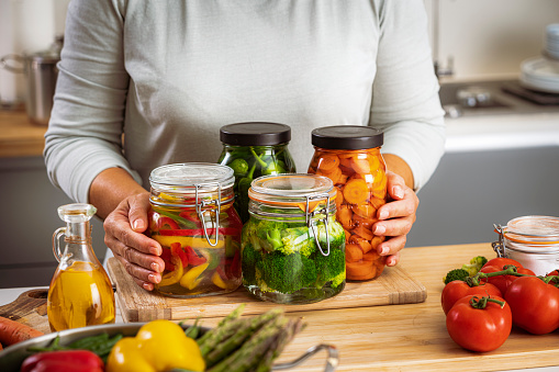 Mature hispanic woman preparing healthy vegetables pickles at home. High resolution 42Mp indoors digital capture taken with SONY A7rII and Zeiss Batis 40mm F2.0 CF lens