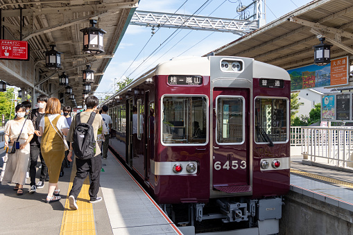 Kyoto, Japan - August 15, 2022 : Passengers at the Arashiyama Station in Kyoto, Japan. It is operated by Hankyu Railway. It is the terminal station of the Hankyu Arashiyama Line.