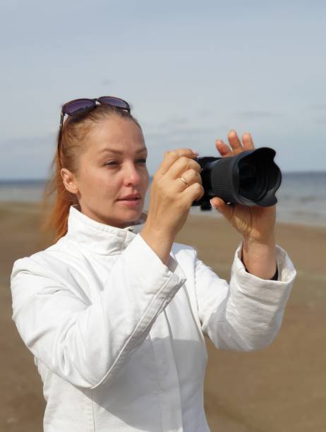 istock a female blogger videotapes a sandy beach, using a mirrorless camera and an electronic steadicam to create content 1431039308