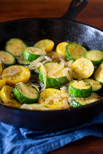 Zucchini and Crookneck (Yellow) Squash sautéed with Vidalia Onions in a Cast Iron Skillet.